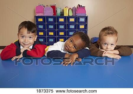 Stock Photography - fort lauderdale, florida, united states of america; three young boys sitting at a table in a classroom. Fotosearch