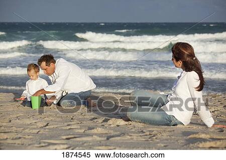 fort lauderdale, florida, united states of america; a father and son play in the sand on the beach while the mother watches View Large Photo Image Stock Photography - fort lauderdale, florida, united states of america; a father and son play in the sand on the beach while the mother watches. Fotosearch