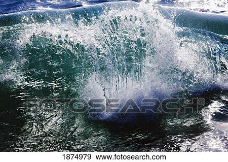 Stock Photo - hawaii, united states of america; sunlight forms rays in sea water just as a wave breaks. Fotosearch