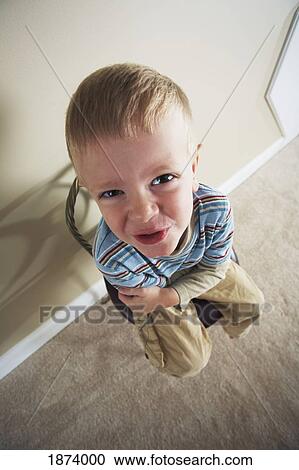 Stock Image - high angle of a boy sitting in a chair. Fotosearch