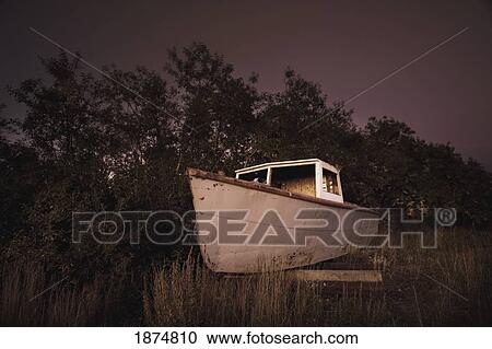 Stock Image - inuvik, northwest territories, canada; an abandoned ship on the riverbank. Fotosearch