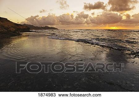 kauai, hawaii, united states of america; sunrise over wave-washed flat reef at the base of the makewehi cliffs near poipu View Large Photo Image Stock Image - kauai, hawaii, united states of america; sunrise over wave-washed flat reef at the base of the makewehi cliffs near poipu. Fotosearch