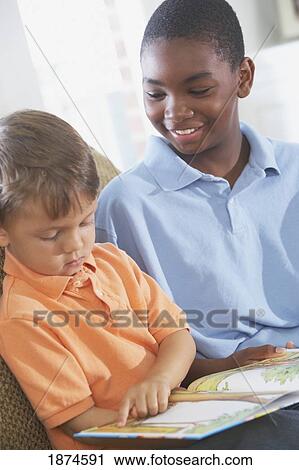 knoxville, tennessee, united states of america; a boy reading to an older boy View Large Photo Image Stock Image - knoxville, tennessee, united states of america; a boy reading to an older boy. Fotosearch