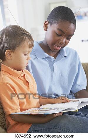 knoxville, tennessee, united states of america; an older boy reading to a younger boy View Large Photo Image Stock Image - knoxville, tennessee, united states of america; an older boy reading to a younger boy. Fotosearch