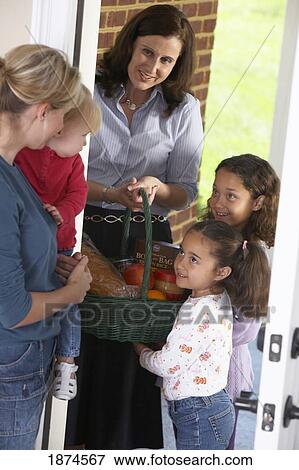 knoxville, tennessee, united states of america; a woman with her two daughters delivering food in a basket to a woman with her child View Large Photo Image Stock Photo - knoxville, tennessee, united states of america; a woman with her two daughters delivering food in a basket to a woman with her child. Fotosearch