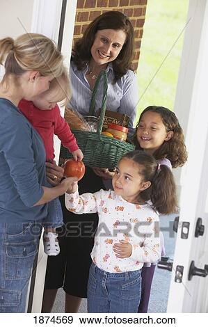 knoxville, tennessee, united states of america; a woman and her two daughters delivering a basket of food to a woman with her child View Large Photo Image Stock Photo - knoxville, tennessee, united states of america; a woman and her two daughters delivering a basket of food to a woman with her child. Fotosearch