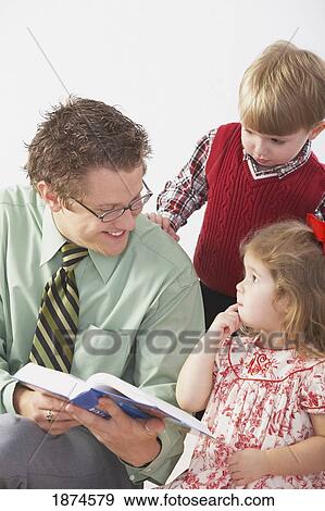knoxville, tennessee, united states of america; a man shows a bible to two young children View Large Photo Image Stock Photo - knoxville, tennessee, united states of america; a man shows a bible to two young children. Fotosearch