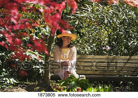 portland, oregon, united states of america; a girl sitting on a park bench looking at the flowers View Large Photo Image Stock Photography - portland, oregon, united states of america; a girl sitting on a park bench looking at the flowers. Fotosearch
