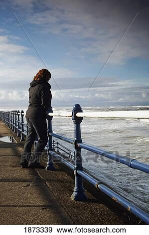 saltburn, teesside, england; a woman standing at a railing and looking out over the ocean View Large Photo Image Stock Photo - saltburn, teesside, england; a woman standing at a railing and looking out over the ocean. Fotosearch