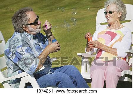 sherwood park, alberta, canada; a couple blowing bubbles while sitting in lawn chairs View Large Photo Image Stock Image - sherwood park, alberta, canada; a couple blowing bubbles while sitting in lawn chairs. Fotosearch