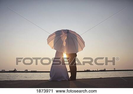 silhouette of a bride and groom behind an umbrella View Large Photo Image Stock Image - silhouette of a bride and groom behind an umbrella. Fotosearch