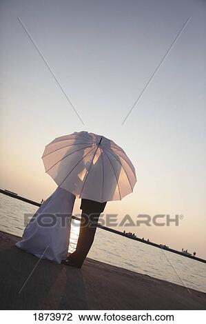 silhouette of a bride and groom behind an umbrella View Large Photo Image Stock Image - silhouette of a bride and groom behind an umbrella. Fotosearch
