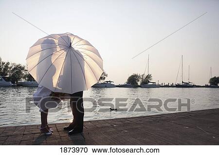 silhouettes of a man and woman behind an umbrella View Large Photo Image Stock Image - silhouettes of a man and woman behind an umbrella. Fotosearch