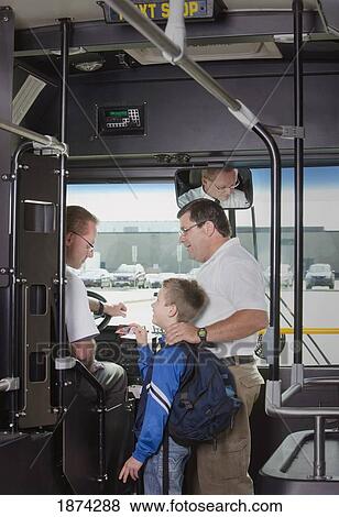 Stock Photo - st. albert, alberta, canada; a father and son talking to the driver as they get on the city bus. Fotosearch