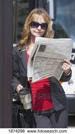 st. albert, alberta, canada; a woman reads the newspaper and holds her travel mug as she waits for the bus View Large Photo Image Stock Photo - st. albert, alberta, canada; a woman reads the newspaper and holds her travel mug as she waits for the bus. Fotosearch