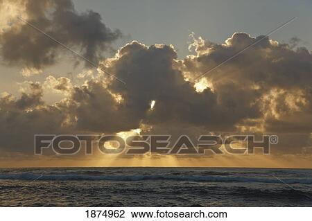 sun rays spread from clouds at sunrise over the ocean View Large Photo Image Stock Image - sun rays spread from clouds at sunrise over the ocean. Fotosearch