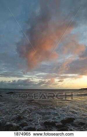 sunset light in the clouds over a rocky shore View Large Photo Image Stock Photography - sunset light in the clouds over a rocky shore. Fotosearch