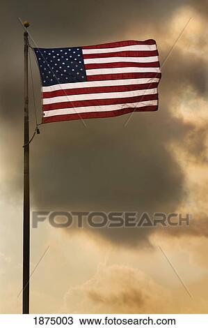 the american flag flying in a cloudy sky View Large Photo Image Stock Image - the american flag flying in a cloudy sky. Fotosearch