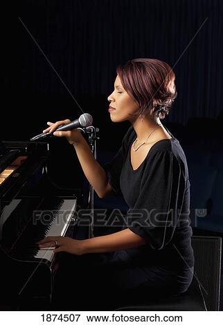 Woman holding microphone View Large Photo Image Stock Photo - Woman holding microphone. Fotosearch