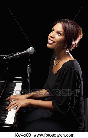 Woman singing into microphone View Large Photo Image Stock Photo - Woman singing into microphone. Fotosearch