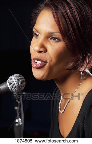 Woman singing into microphone View Large Photo Image Stock Photography - Woman singing into microphone. Fotosearch