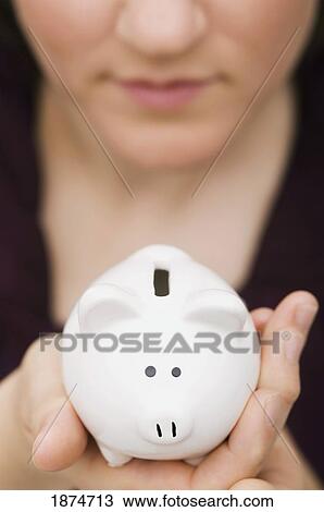Stock Image - woman with a piggy bank. Fotosearch