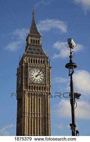 a clock tower with a spire and a lamp post View Large Photo Image Stock Photo - a clock tower with a spire and a lamp post. Fotosearch