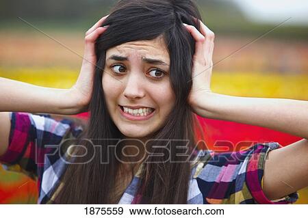 a girl holding her head with a crazy face View Large Photo Image Stock Photo - a girl holding her head with a crazy face. Fotosearch