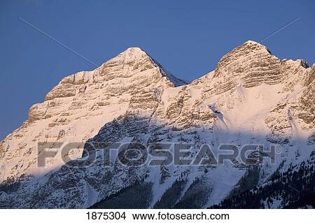 Picture - alberta, canada; snow covered mountain peaks at sunrise in kananaskis country. Fotosearch