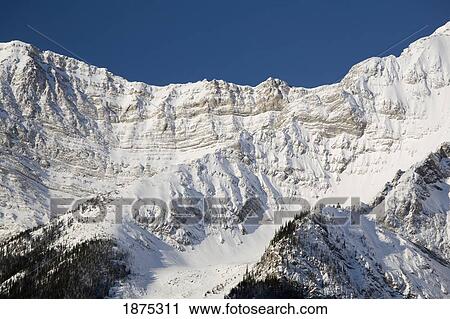 Stock Image - alberta, canada; snow covered mountain ridge and cliff in kananaskis country. Fotosearch