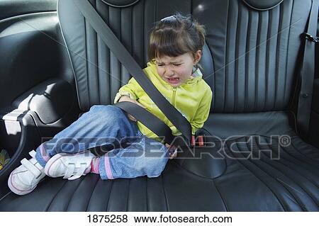 Stock Photo - cadiz, spain; a young girl cries as she sits in a vehicle wearing a seat belt. Fotosearch