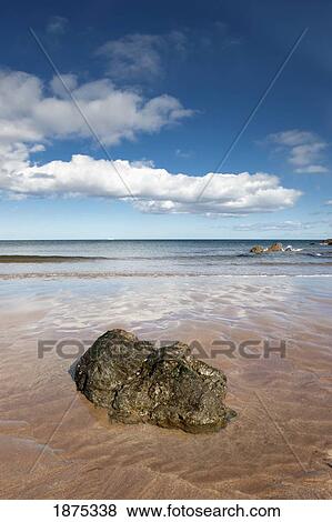 northumberland, england; a rock sitting in shallow water at low newton beach View Large Photo Image Stock Photo - northumberland, england; a rock sitting in shallow water at low newton beach. Fotosearch