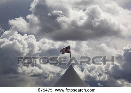 Stock Photography - oregon, united states of america; the american flag flying under dark cumulus clouds. Fotosearch