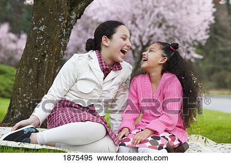 Stock Photography - portland, oregon, united states of america; girls laughing under a cherry blossom tree. Fotosearch