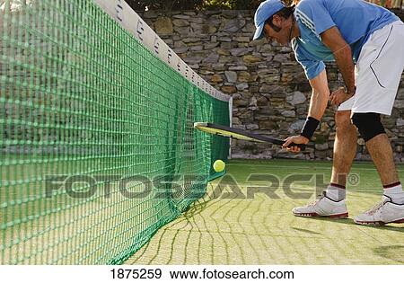Stock Photo - tarifa, cadiz, andalusia, spain; a man plays tennis at the hotel dos mares tennis court. Fotosearch