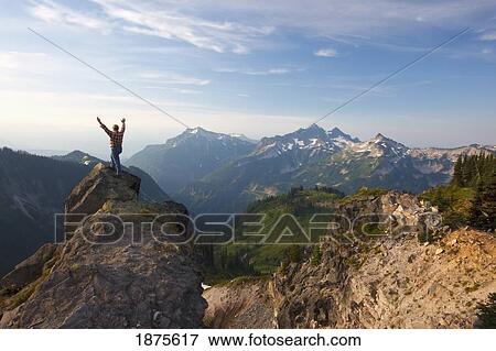 washington, united states of america; a man with his hands raised standing on a rock overlooking the tatoosh mountains in paradise park in mt. rainier national park View Large Photo Image Stock Photo - washington, united states of america; a man with his hands raised standing on a rock overlooking the tatoosh mountains in paradise park in mt. rainier national park. Fotosearch