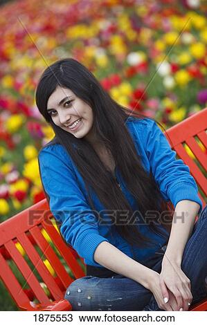 Stock Image - woodburn, oregon, united states of america; a girl on a bench at the wooden shoe tulip farm. Fotosearch
