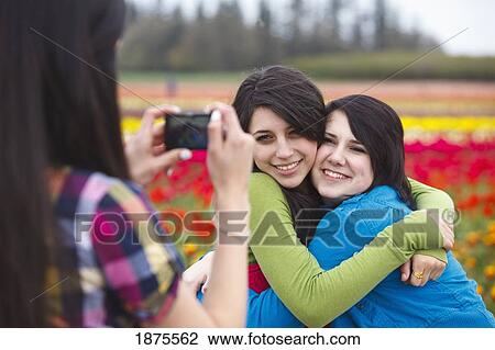woodburn, oregon, united states of america; two girls hugging as another girl takes their picture at the wooden shoe tulip farm View Large Photo Image Stock Image - woodburn, oregon, united states of america; two girls hugging as another girl takes their picture at the wooden shoe tulip farm. Fotosearch