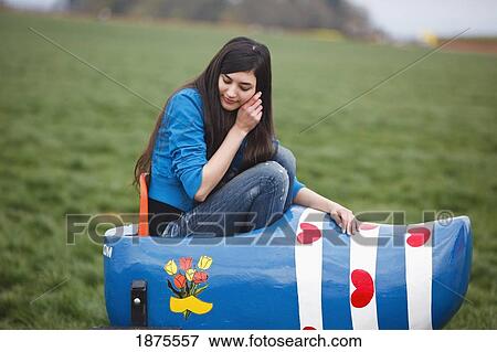 Stock Photo - woodburn, oregon, united states of america; a girl sitting in a painted wooden shoe at the wooden shoe tulip farm. Fotosearch
