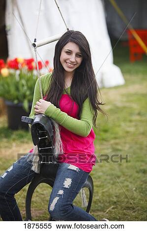 Stock Photography - woodburn, oregon, united states of america; a girl sitting on a horse tire swing at the wooden shoe tulip farm. Fotosearch