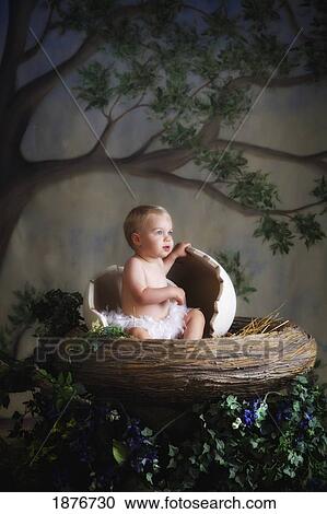 Stock Image - A Baby Posed In A Bird's Nest. Fotosearch