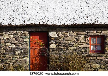 Bonane, County Kerry, Ireland; A Stone House With An Orange Door And Window Frame And Snow On The Roof View Large Photo Image Stock Image - Bonane, County Kerry, Ireland; A Stone House With An Orange Door And Window Frame And Snow On The Roof. Fotosearch