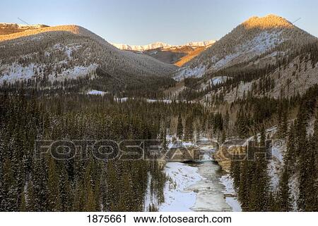 Stock Image - Bragg Creek, Alberta, Canada; Winter Sunrise On The Elbow Falls And The Canadian Rockies. Fotosearch