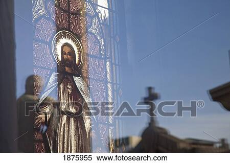 Stock Photography - Buenos Aires, Argentina; A Stained Glass Window Depicting Jesus With A Reflection Of A Cross In Recoleta Cemetery. Fotosearch