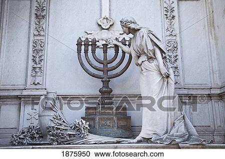 Stock Image - Buenos Aires, Argentina; A Stone Statue Of An Angel Lighting A Candelabra In Recoleta Cemetery. Fotosearch