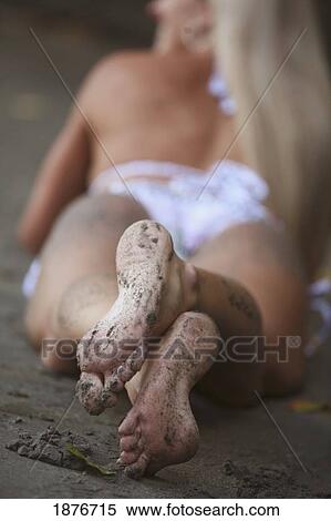 Stock Photography - Grand Prairie, Alberta, Canada; A Woman's Feet Covered In Sand While Laying On The Beach Wearing A Bathing Suit. Fotosearch