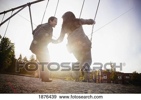 Hamilton, Ontario, Canada; A Couple On The Swings At The Playground View Large Photo Image Stock Photo - Hamilton, Ontario, Canada; A Couple On The Swings At The Playground. Fotosearch