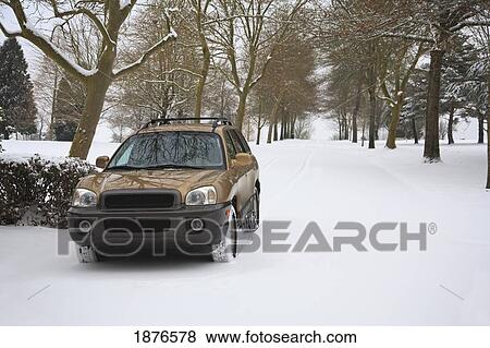 Stock Photo - Happy Valley, Oregon, United States Of America; A Car Traveling On A Snowy Road Through A Park. Fotosearch