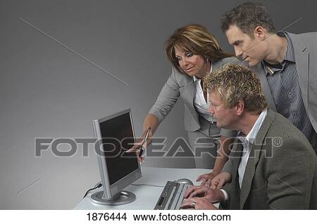 Jordan, Ontario, Canada; A Woman And Two Men Working At A Computer View Large Photo Image Picture - Jordan, Ontario, Canada; A Woman And Two Men Working At A Computer. Fotosearch