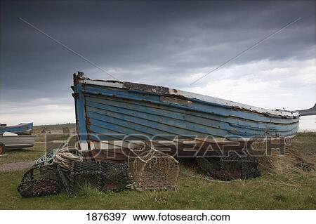 Stock Photo - Lindisfarne, Northumberland, England; A Boat And Fishing Traps On The Shore. Fotosearch